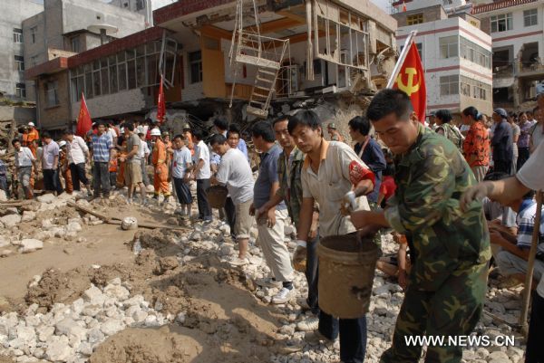 Local people take part in the rescue work in landslides-hit Zhouqu County, Gannan Tibetan Autonomous Prefecture in northwest China&apos;s Gansu Province, Aug. 9, 2010. Recuers have saved 77 people from rain-triggered landslides in Zhouqu County as of 11:00 AM local time (0300 GMT) Aug. 9. 