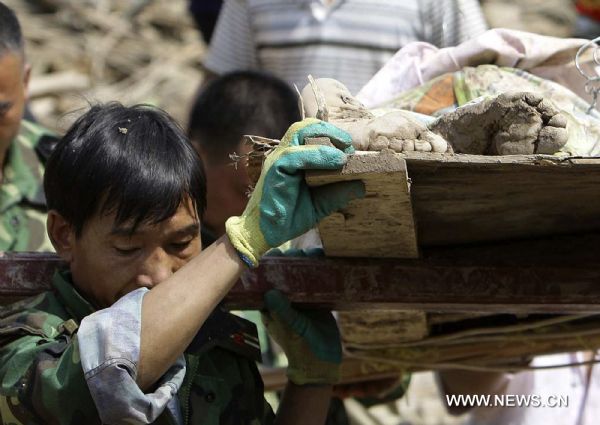 Rescuers carry a victim&apos;s body in landslides-hit Zhouqu County, Gannan Tibetan Autonomous Prefecture in northwest China&apos;s Gansu Province, Aug. 9, 2010. 