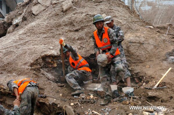 Rescuers dig up silt which submerged a building in landslides-hit Zhouqu County, Gannan Tibetan Autonomous Prefecture in northwest China&apos;s Gansu Province, Aug. 9, 2010.