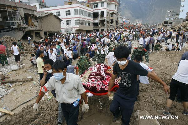 Rescuers carry a victim's body in landslides-hit Zhouqu County, Gannan Tibetan Autonomous Prefecture in northwest China's Gansu Province, Aug. 9, 2010.