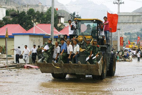 A bulldozer transports rescuers and local residents in landslides-hit Zhouqu County, Gannan Tibetan Autonomous Prefecture in northwest China's Gansu Province, Aug. 9, 2010. 