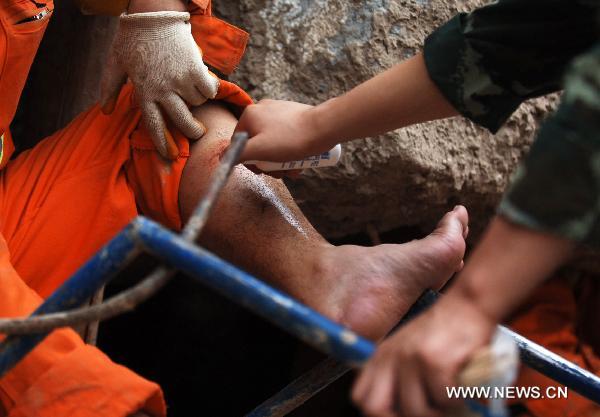 Rescuers work at a residence building in the mudslides-hit Zhouqu County, Gannan Tibetan Autonomous Prefecture in northwest China's Gansu Province, Aug. 10, 2010. 