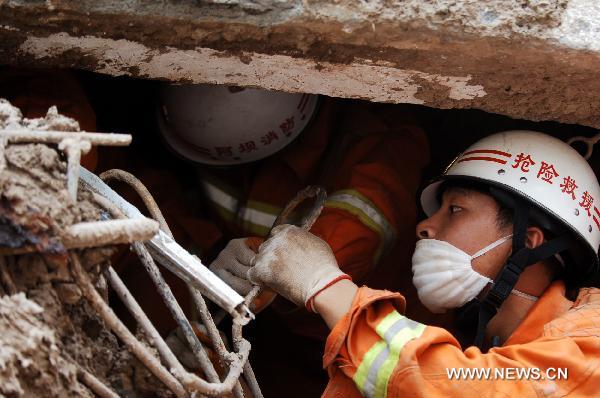 Rescuers work at a residence building in the mudslides-hit Zhouqu County, Gannan Tibetan Autonomous Prefecture in northwest China's Gansu Province, Aug. 10, 2010.