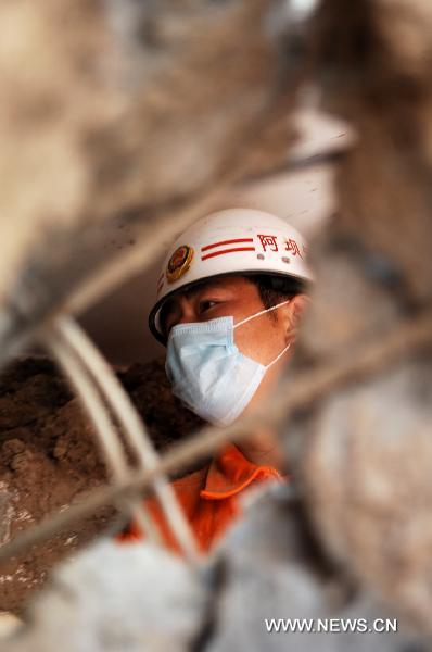 Rescuers work at a residence building in the mudslides-hit Zhouqu County, Gannan Tibetan Autonomous Prefecture in northwest China's Gansu Province, Aug. 10, 2010.