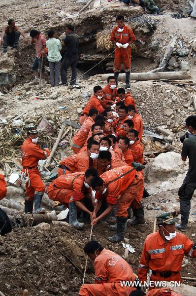 Rescuers work at a residence building in the mudslides-hit Zhouqu County, Gannan Tibetan Autonomous Prefecture in northwest China's Gansu Province, Aug. 10, 2010.