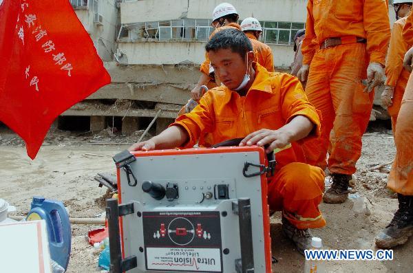 A firefighter operates the life detector to search for survivors in the mudslide-hit Zhouqu County, Gannan Tibetan Autonomous Prefecture in northwest China's Gansu Province, Aug. 10, 2010.