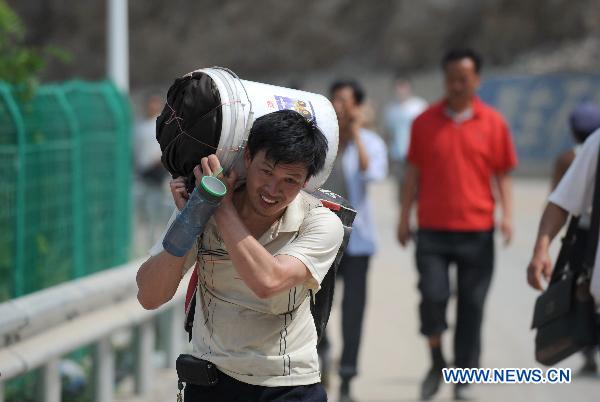 A man carries home relief materials in the landslides-hit Zhouqu County, Gannan Tibetan Autonomous Prefecture in northwest China's Gansu Province, Aug. 10, 2010.