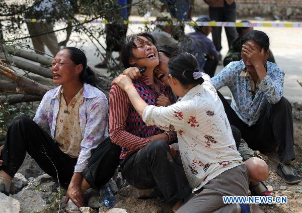 Women grieve for their relatives dead in the landslide in Zhouqu County, Gannan Tibetan Autonomous Prefecture in northwest China's Gansu Province, Aug. 10, 2010.