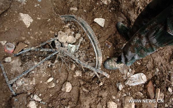 The photo taken on Aug. 9, 2010, shows a destroyed bike wheel stuck in the debris. With the progress of rescue work, everyday life articles gradually emerged from debris of the massive rain-triggered mudslide in Zhouqu County in northwest China's Gansu Province, recalling people's memories of peaceful life before the disaster.