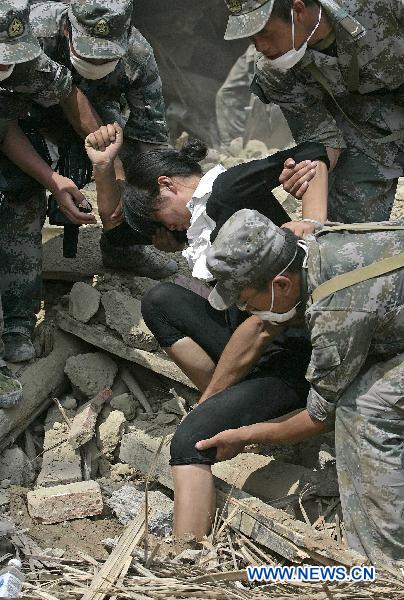 Soldiers help a woman get off from a pit in landslides-hit Zhouqu County, Gannan Tibetan Autonomous Prefecture in northwest China's Gansu Province, Aug. 10, 2010. 