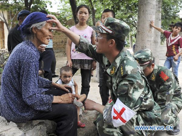 A medic checks an elder woman's eyes in landslides-hit Zhouqu County, Gannan Tibetan Autonomous Prefecture in northwest China's Gansu Province, Aug. 10, 2010.