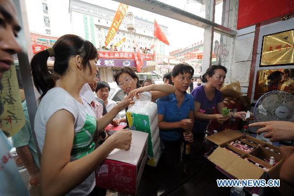 Customers buy commodities in Hongyuan Supermarket in mudslide-hit Zhouqu County, northwest China's Gansu Province, Aug. 11, 2010.