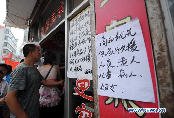 A notice on the door of Hongyuan Supermarket reads 'The priority of commodity shopping is given to rescuers, the aged, children, sick persons and women', in mudslide-hit Zhouqu County, northwest China's Gansu Province, Aug. 11, 2010. 
