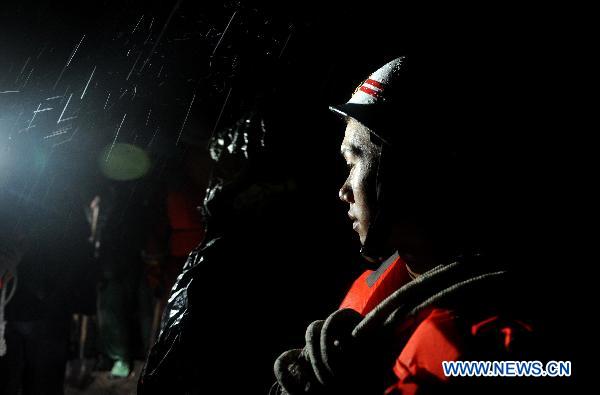 Rescuers work in the rain in Zhouqu County, Gannan Tibetan Autonomous Prefecture in northwest China's Gansu Province, Aug. 11, 2010. 