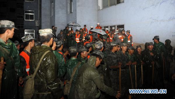 Rescuers work in the rain in Zhouqu County, Gannan Tibetan Autonomous Prefecture in northwest China's Gansu Province, Aug. 11, 2010.