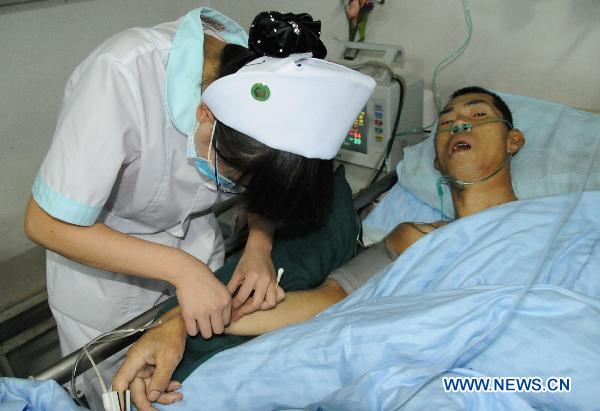 A nurse gives transfusion to survivor Liuma Shengdai in Lanzhou, capital of northwest China's Gansu Province, Aug. 11, 2010. 