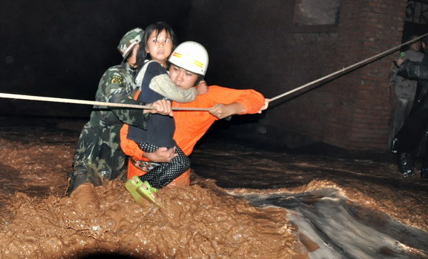 Armed Police officers rescue residents in Wuzhong City, Ningxia Hui Autonomous Region, from their flooded homes on Aug. 11, 2010.