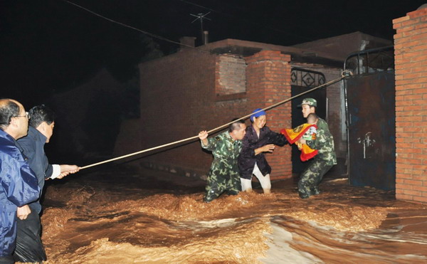 Armed Police officers rescue residents in Wuzhong City, Ningxia Hui Autonomous Region, from their flooded homes on Aug. 11, 2010.