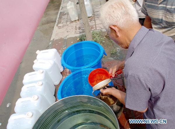 An old man takes purified water in Zhouqu County, Gannan Tibetan Autonomous Prefecture in northwest China's Gansu Province, Aug. 11, 2010. 