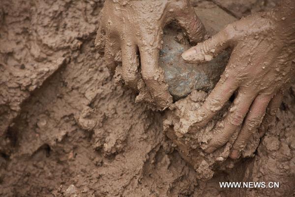 A young soldier clears muddy stones in Zhouqu County, Gannan Tibetan Autonomous Prefecture in northwest China's Gansu Province, Aug. 12, 2010. Young soldiers born after 1990 took responsibility of important tasks of the rescue mission in landslide-hit Zhouqu.