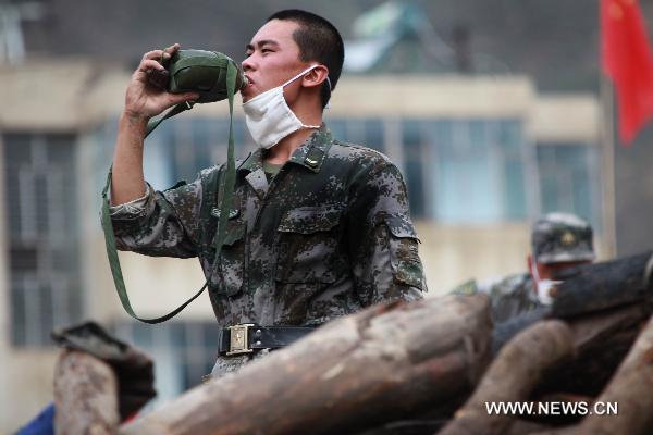 A young soldier drinks water in Zhouqu County, Gannan Tibetan Autonomous Prefecture in northwest China's Gansu Province, Aug. 12, 2010. 