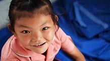 Seven-year-old Liu Hui plays in a tent at a temporary shelter place in landslide-hit Zhouqu County, Gannan Tibetan Autonomous Prefecture in northwest China's Gansu Province, Aug. 12, 2010.