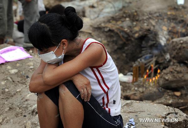 A resident cries for her relative killed by landslide in Zhouqu County, Gannan Tibetan Autonomous Prefecture in northwest China's Gansu Province, Aug. 12, 2010.