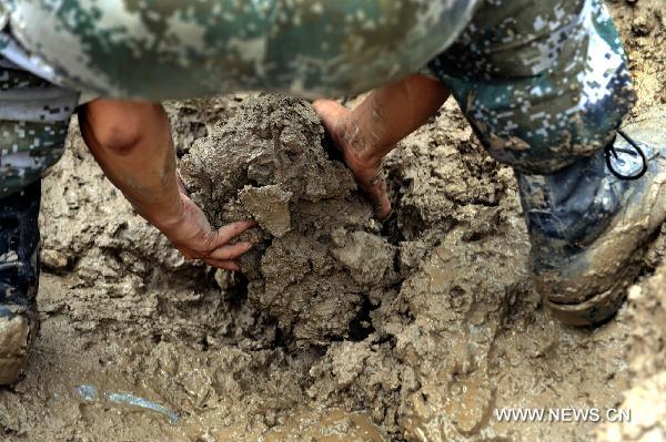 A soldiers works at landslide-hit Zhouqu County, Gannan Tibetan Autonomous Prefecture in northwest China's Gansu Province, Aug. 12, 2010.