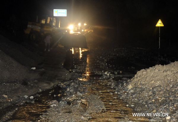 A bulldozer cleans off mud and stones on a road in Wenxian County, northwest China's Gansu Province. Five villages of Wenxian County encountered with landslides triggered by continuous heavy rains, with no casaulties but nine residential houses, two roads and parts of power networks damaged. (Xinhua/Liu Eryin) (zn) 