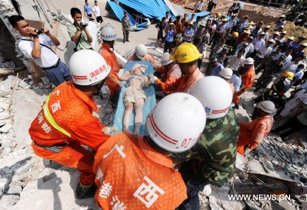 Rescuers carry an injured child just saved from a building collapse site in Qiaoxu Town of Guigang, a city of southwest China's Guangxi Zhuang Autonomous Region, Aug. 13, 2010. A three-story building in Qiaoxu Town partly collapsed on Friday morning, with many residents trapped inside, Local officials said. (Xinhua/Li Bin) (zn) 