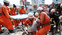 Rescuers carry an injured child just saved from a building collapse site in Qiaoxu Town of Guigang, a city of southwest China's Guangxi Zhuang Autonomous Region, Aug. 13, 2010. A three-story building in Qiaoxu Town partly collapsed on Friday morning, with many residents trapped inside, Local officials said.