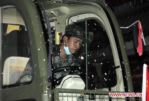 A soldier drives a shovel truck to clear up road surface in landslide-hit Zhouqu County, northwest China&apos;s Gansu Province, early Aug. 13, 2010.