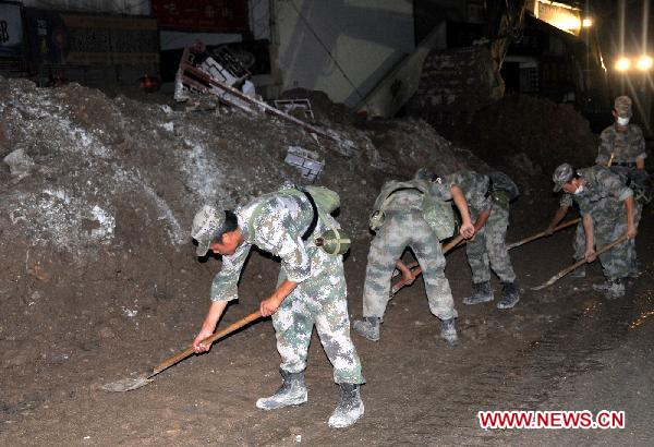 Soldiers clear road surface in landslide-hit Zhouqu County, northwest China&apos;s Gansu Province, early Aug. 13, 2010. 