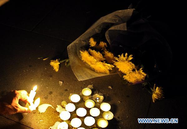 A participant lights up candles during a mourning activity in Shijiazhuang, capital of north China's Hebei Province, Aug. 15, 2010, to mourn for the victims of the Aug. 8 mudslide disaster in Zhouqu County, Gannan Tibetan Autonomous Prefecture in northwest China's Gansu Province.