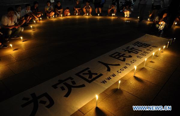 People light up candles during a mourning activity in Shijiazhuang, capital of north China's Hebei Province, Aug. 15, 2010, to mourn for the victims of the Aug. 8 mudslide disaster in Zhouqu County, Gannan Tibetan Autonomous Prefecture in northwest China's Gansu Province.