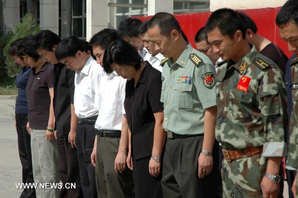 Staff members of the Chinese Embassy pay a silent tribute to the victims of the Aug. 8 mudslide disaster in Zhouqu County, Gannan Tibetan Autonomous Prefecture in northwest China's Gansu Province, in Kabul, capital of Afghanistan, Aug. 15, 2010.