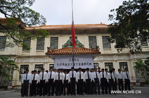 The national flag of China is seen at half mast as Chinese people pay a silent tribute to the victims of the Aug. 8 mudslide disaster in Zhouqu County, Gannan Tibetan Autonomous Prefecture in northwest China's Gansu Province, at the Chinese Embassy in Hanoi, capital of Vietnam, Aug. 15, 2010. 