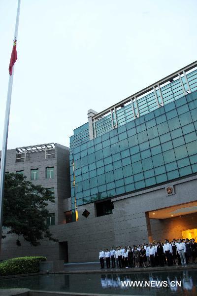 The national flag of China flies at half mast as staff members pay a silent tribute to the victims of the Aug. 8 mudslide disaster in Zhouqu County, Gannan Tibetan Autonomous Prefecture in northwest China's Gansu Province, at the Chinese Embassy in Singapore, Aug. 15, 2010.