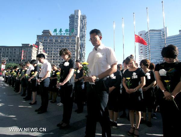 People pay a silent tribute in Shijiazhuang, captial of norht China's Hebei Province, Aug. 15, 2010, to mourn for the victims of the Aug. 8 mudslide disaster in Zhouqu County, Gannan Tibetan Autonomous Prefecture in northwest China's Gansu Province. 