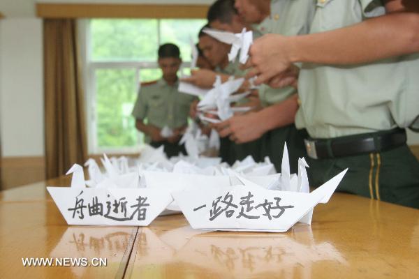 Members of armed police for frontier guard make paper cranes and boats in Shenzhen, south China's Guangdong Province, Aug. 15, 2010, to mourn for the victims of the Aug. 8 mudslide disaster in Zhouqu County, Gannan Tibetan Autonomous Prefecture in northwest China's Gansu Province. 