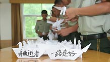 Members of armed police for frontier guard make paper cranes and boats in Shenzhen, south China's Guangdong Province, Aug. 15, 2010, to mourn for the victims of the Aug. 8 mudslide disaster in Zhouqu County, Gannan Tibetan Autonomous Prefecture in northwest China's Gansu Province.