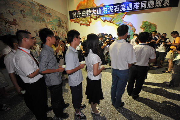 People line up to present flowers in commemoration of the victims in the Zhouqu landslide disaster at the Gansu Pavilion, Shanghai, August 15, 2010.