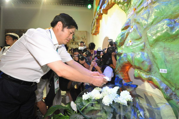 A man presents flowers in commemoration of the victims in the Zhouqu landslide disaster at the Gansu Pavilion, Shanghai, August 15, 2010.