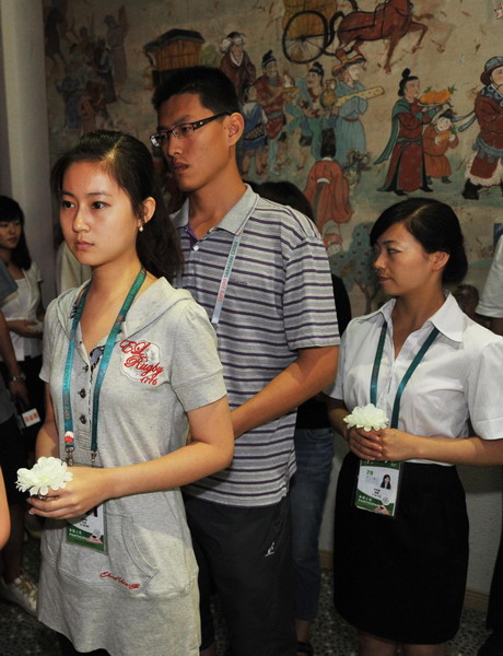 People wait in line to present flowers to express their tribute for the victims in the Zhouqu mudslide disaster of Northwest China's Gansu province in Shanghai on August 15, 2010