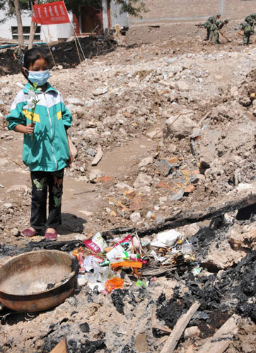 Wang Jinyan, 8, mourns the loss of her friends in front of a ruined home in mudslide-hit Zhouqu, northwest China's Gansu Province. 