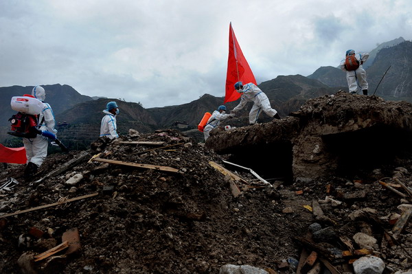 Health workers from Zhangzhou epidemic prevention station perform decontamination work at Yueyuan village of Zhouqu County, northwest China&apos;s Gansu Province, Aug 14, 2010.