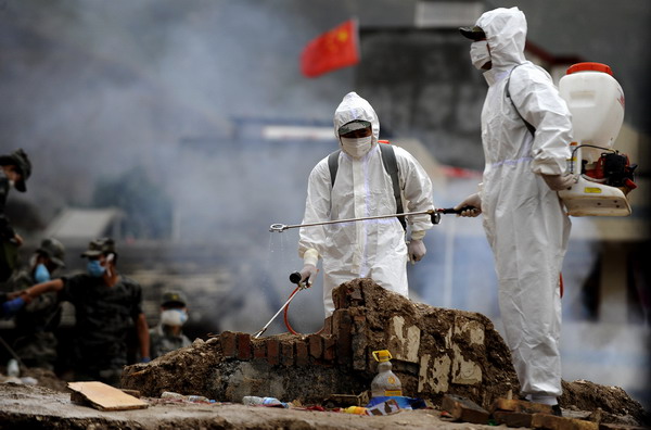 Health workers from Zhangzhou epidemic prevention station perform decontamination work at Yueyuan village of Zhouqu County, northwest China&apos;s Gansu Province, Aug 14, 2010.