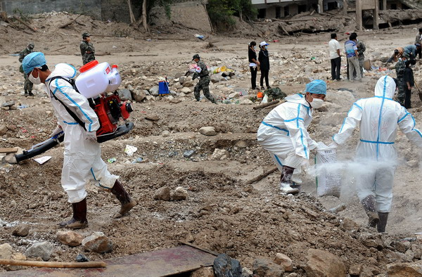 Health workers from Zhangzhou epidemic prevention station perform decontamination work at Yueyuan village of Zhouqu County, northwest China&apos;s Gansu Province, Aug 14, 2010.