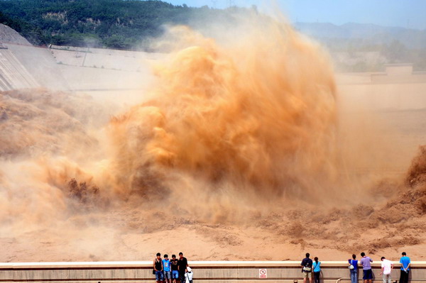 Spectators observe the flood discharge process at the Xiaolangdi Reservoir on the Yellow River in Jiyuan, central China's Henan Province, August 16, 2010. 