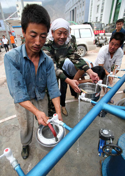 Local people get drinking water from a newly-dug well in Zhouqu county on Monday.